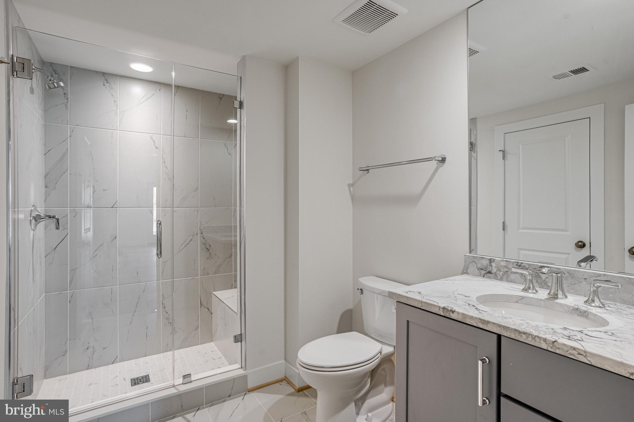1002 Springvale Road Great Falls, VA 22066 - Photo 105 of 114 a bathroom with a granite countertop sink a toilet and shower
