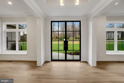 a kitchen with stainless steel appliances kitchen island granite countertop a dining table chairs and white cabinets