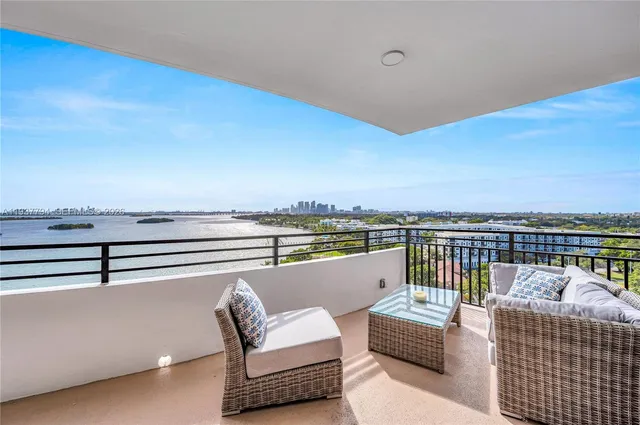 a view of a roof deck with couches and ocean view