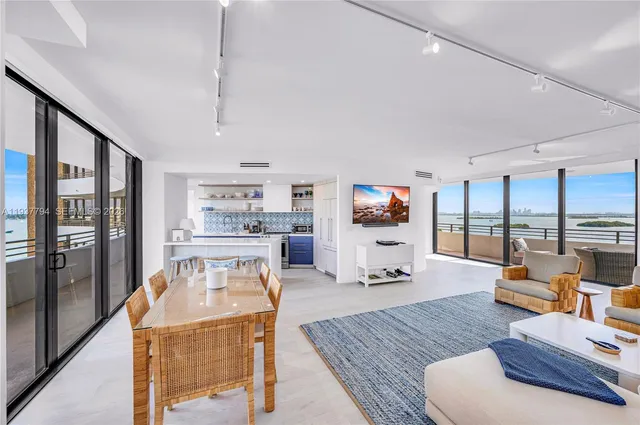 a living room with furniture flat screen tv and a floor to ceiling window