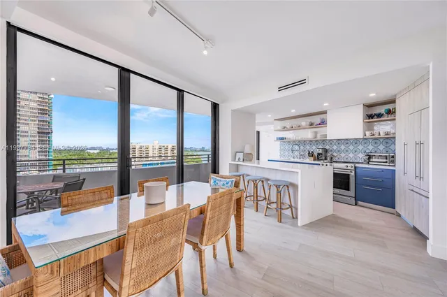 a open kitchen with stainless steel appliances granite countertop a stove top oven a sink and a dining table with garden view