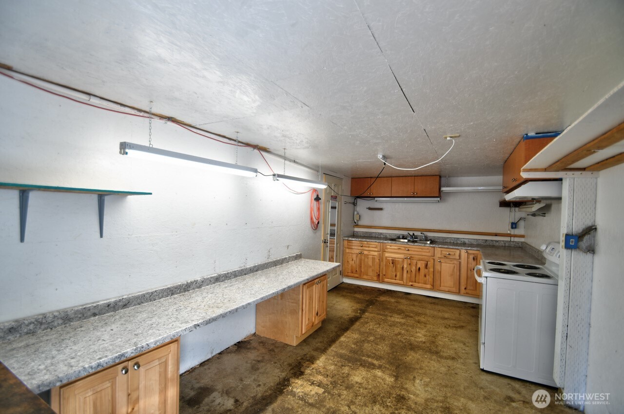 220 West Buck Prairie Road Elma, WA 98541 - Photo 22 of 30 a kitchen with stainless steel appliances granite countertop a sink and cabinets