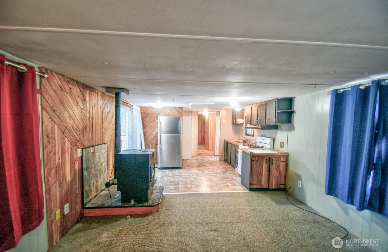 220 West Buck Prairie Road Elma, WA 98541 - Photo 6 of 30 a view of a hallway with kitchen and refrigerator