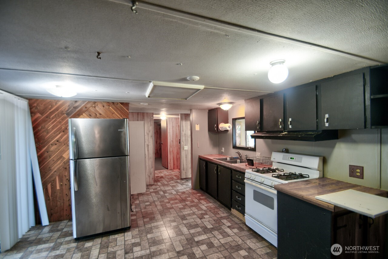 220 West Buck Prairie Road Elma, WA 98541 - Photo 8 of 30 a kitchen with stainless steel appliances granite countertop a refrigerator a stove and a sink