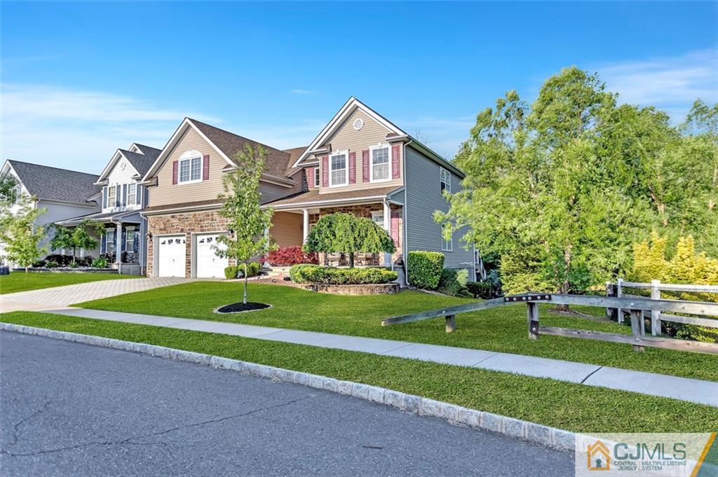 a front view of a house with a yard and trees