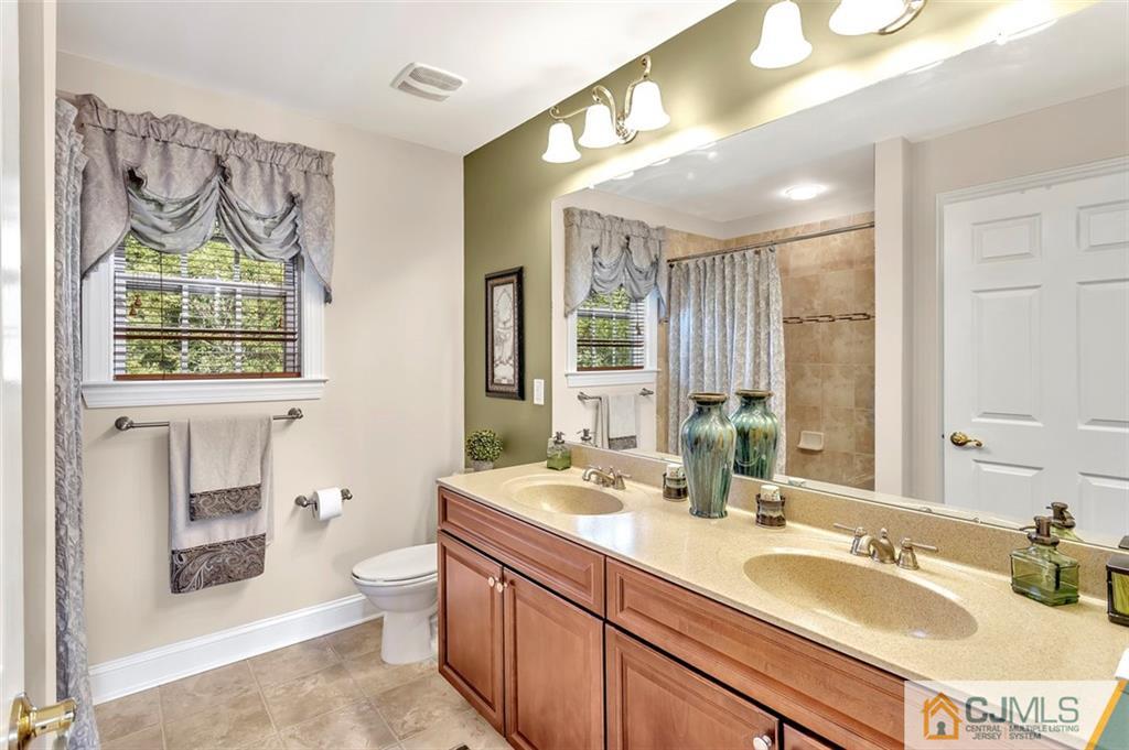 87 Willocks Circle Somerset, NJ 08873 - Photo 30 of 31 a bathroom with double vanity sink a two mirror a toilet and a window