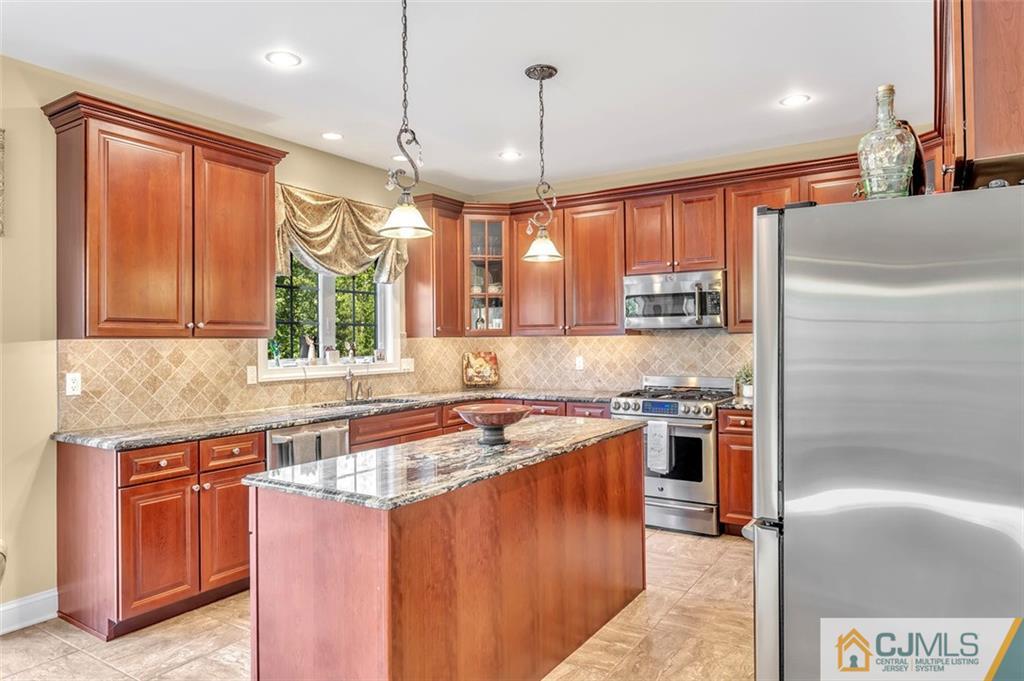 87 Willocks Circle Somerset, NJ 08873 - Photo 7 of 31 a kitchen with stainless steel appliances granite countertop a sink stove and refrigerator