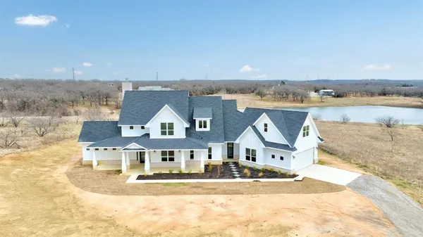an aerial view of residential houses with outdoor space and lakeside