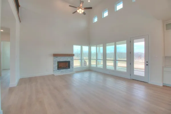a view of an empty room with a kitchen and window