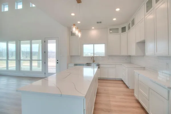a large white kitchen with lots of counter space and a sink