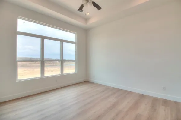 an empty room with a window and a ceiling fan