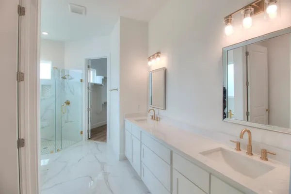 a spacious bathroom with a double vanity sink mirror and shower