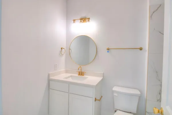 a bathroom with a toilet a sink and mirror