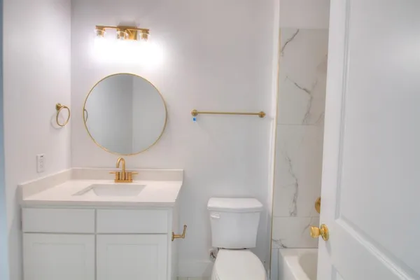 a bathroom with a toilet sink and mirror