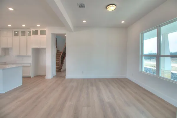 a view of an empty room with a fireplace and a window