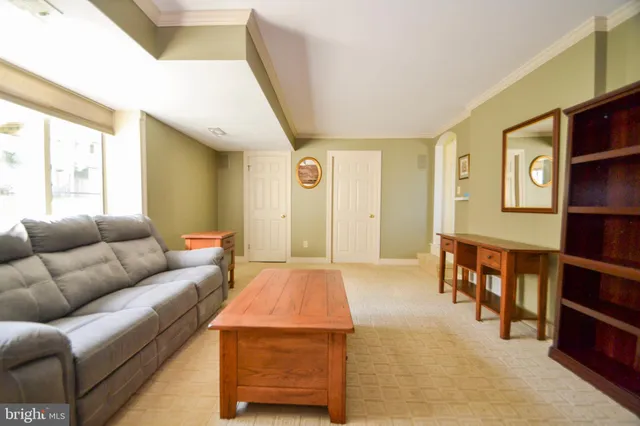 a living room with furniture and a book shelf