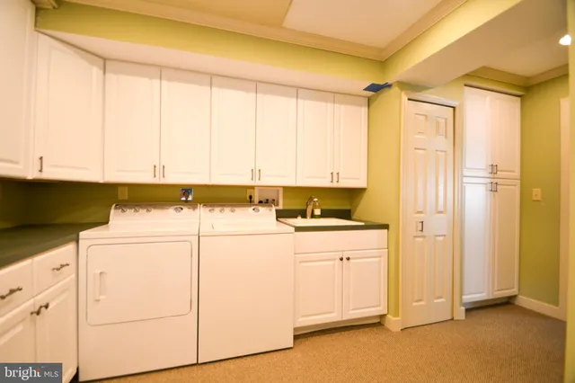 a utility room with cabinets washer and dryer