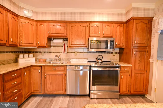 a kitchen with stainless steel appliances granite countertop a stove a sink and a microwave