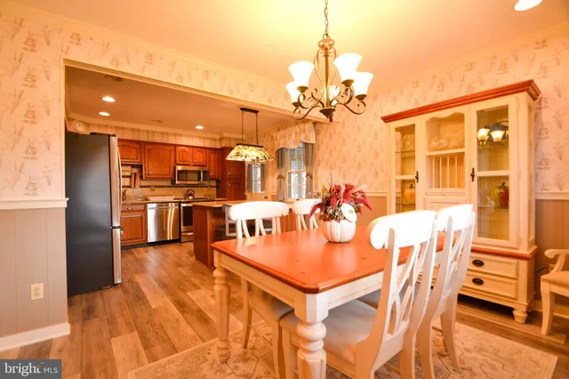 a dining room with furniture a chandelier and wooden floor