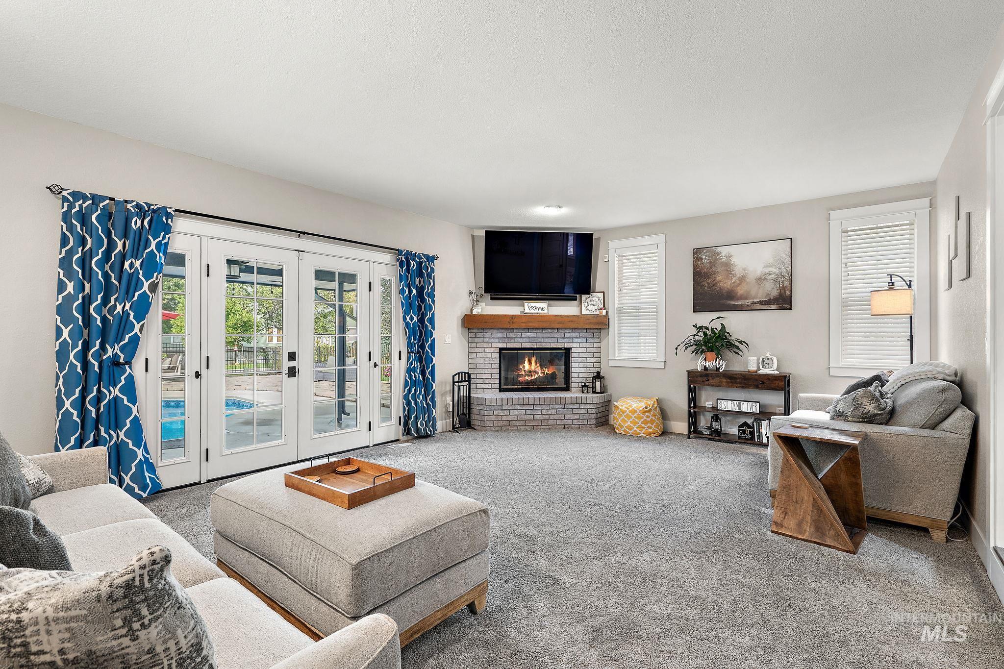 5363 North Hickory Run Place Boise, ID 83713 - Photo 16 of 50 Living room with healthy amount of natural light, carpet, a brick fireplace, and french doors