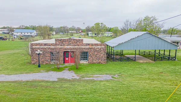 a aerial view of a house with a big yard and large trees