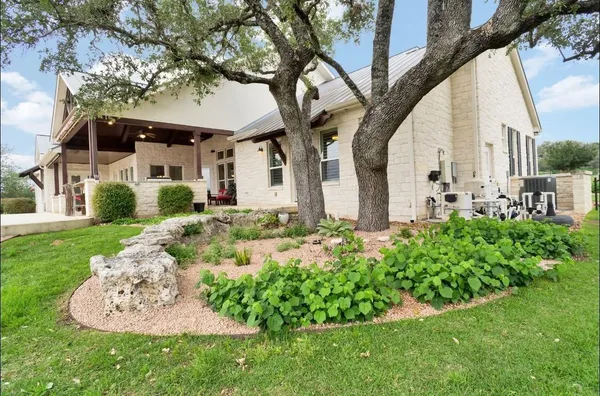 a front view of a house with a garden and fountain