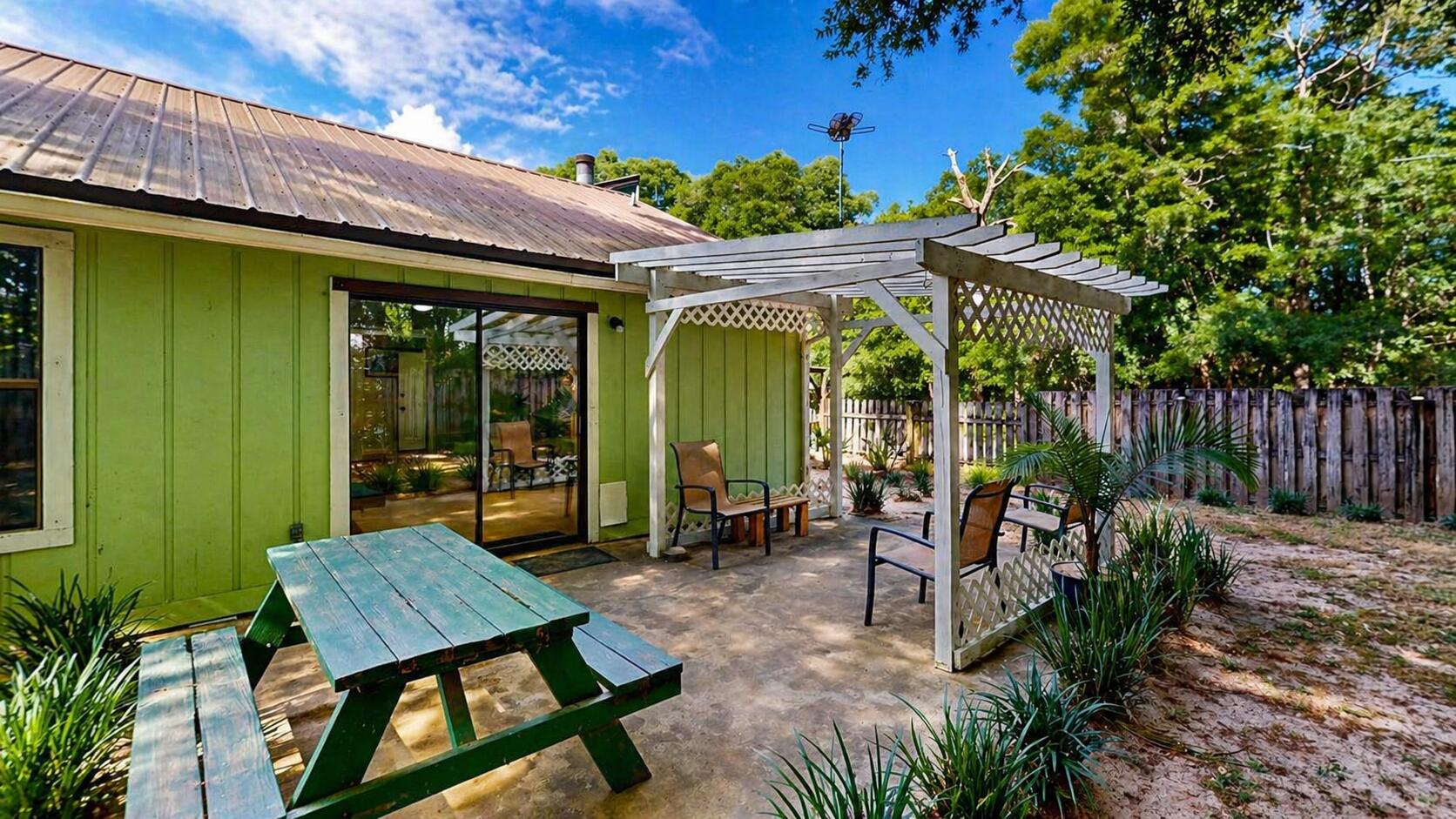 118 Fairoaks Drive Crestview, FL 32539 - Photo 21 of 23 a view of a patio with table and chairs potted plants and large tree