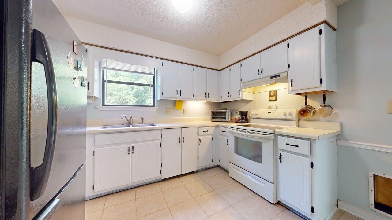 118 Fairoaks Drive Crestview, FL 32539 - Photo 6 of 23 a kitchen with granite countertop white cabinets and white appliances
