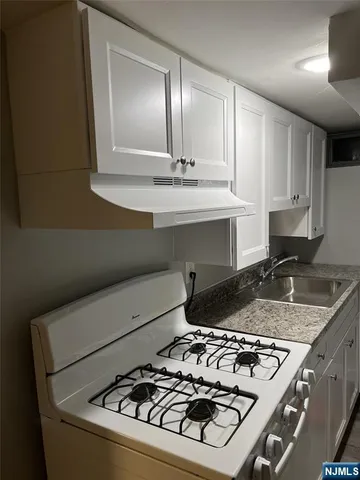 a kitchen with granite countertop a stove and a sink