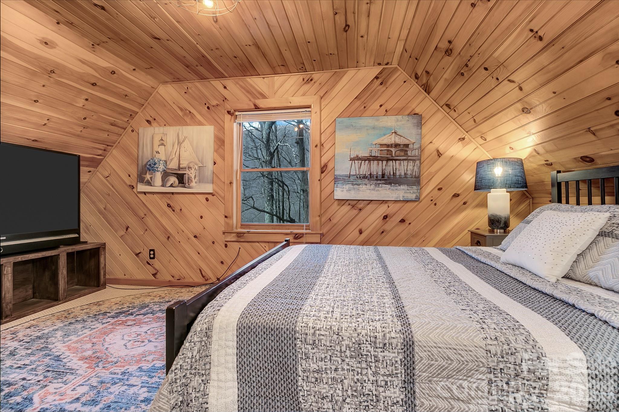 135 Pretty Ridge Maggie Valley, NC 28751 - Photo 39 of 46 a bedroom with a bed and a flat tv screen next to a window