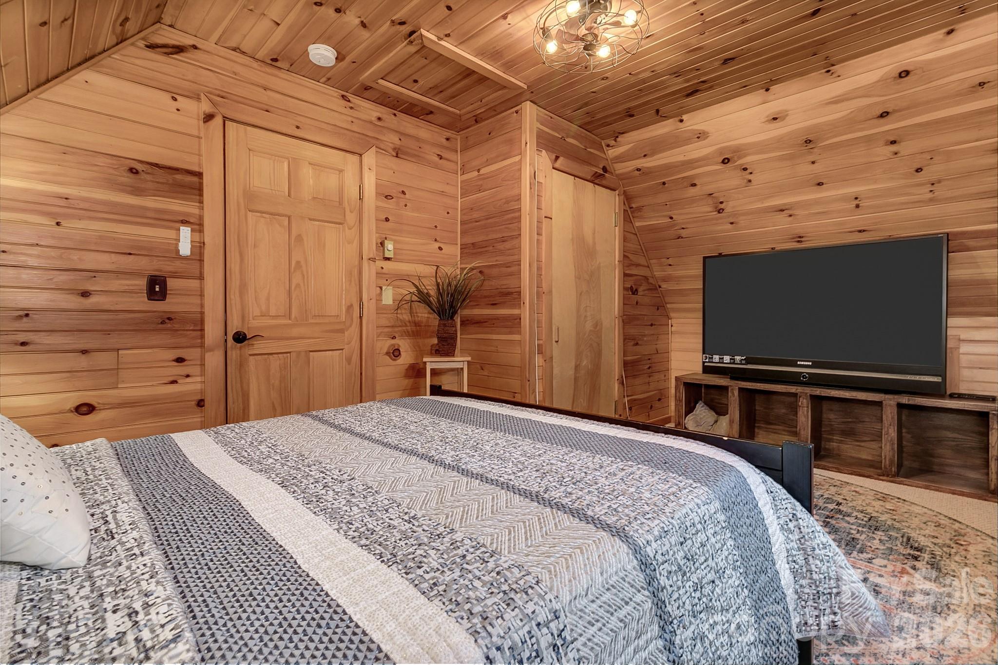 135 Pretty Ridge Maggie Valley, NC 28751 - Photo 40 of 46 a bedroom with a bed and a flat screen tv