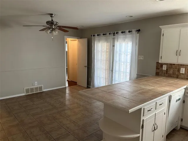 an empty room with windows and cabinet