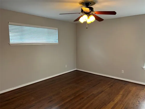 a view of a small space with wooden floor a chandelier fan and a window