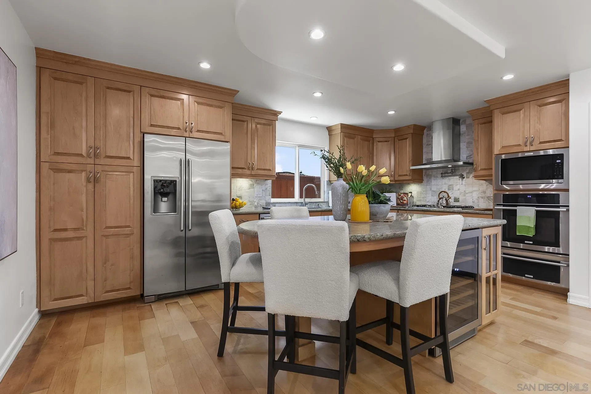 10371 Strathmore Drive Santee, CA 92071 - Photo 17 of 58 a kitchen with stainless steel appliances granite countertop a dining table chairs refrigerator and microwave