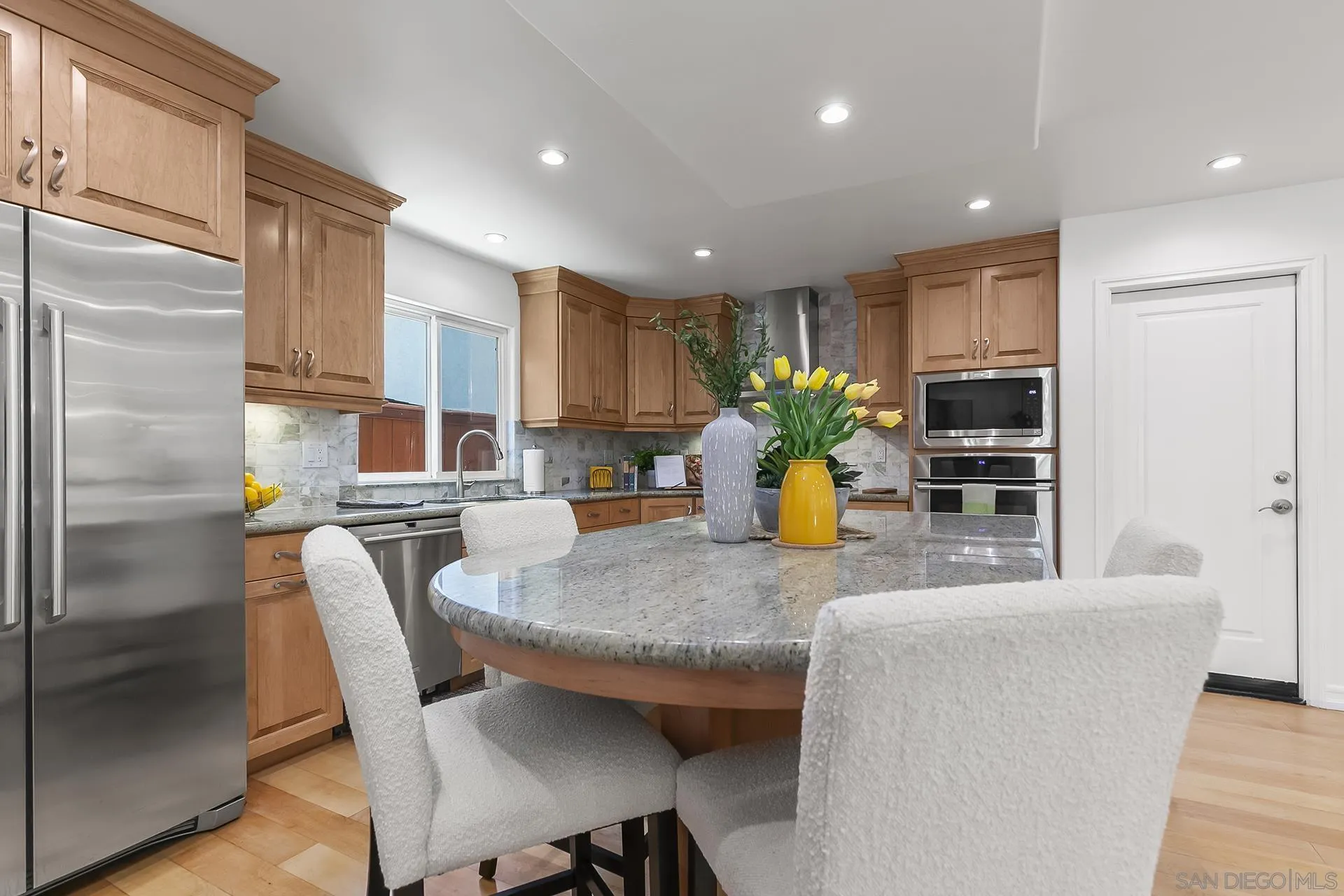 10371 Strathmore Drive Santee, CA 92071 - Photo 18 of 58 a kitchen with stainless steel appliances granite countertop a refrigerator a sink a stove a dining table and chairs