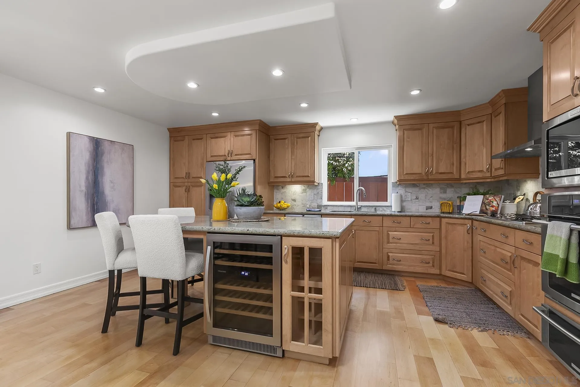 10371 Strathmore Drive Santee, CA 92071 - Photo 21 of 58 a kitchen with stainless steel appliances granite countertop a table chairs sink and cabinets