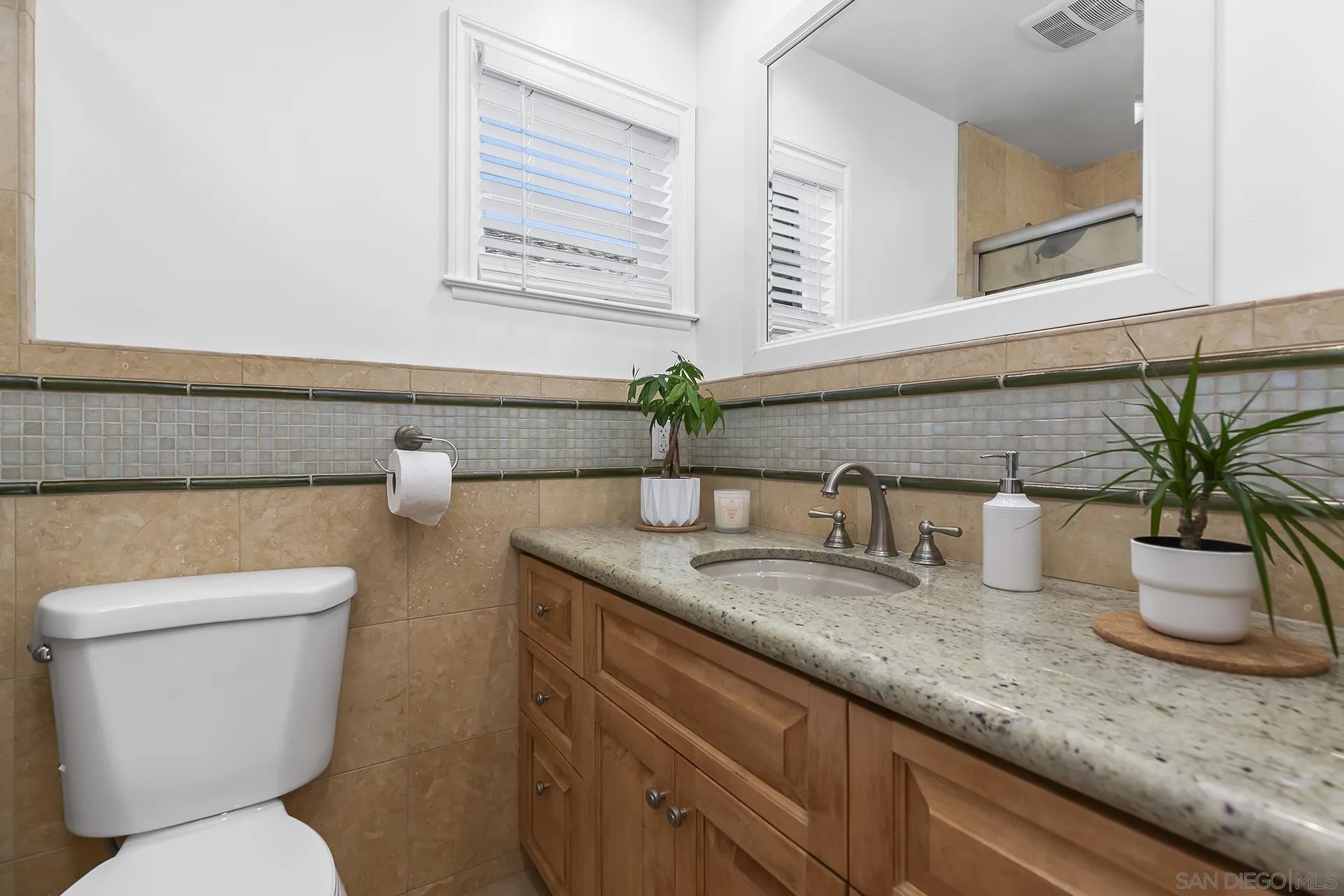 10371 Strathmore Drive Santee, CA 92071 - Photo 38 of 58 a bathroom with a granite countertop toilet sink and mirror