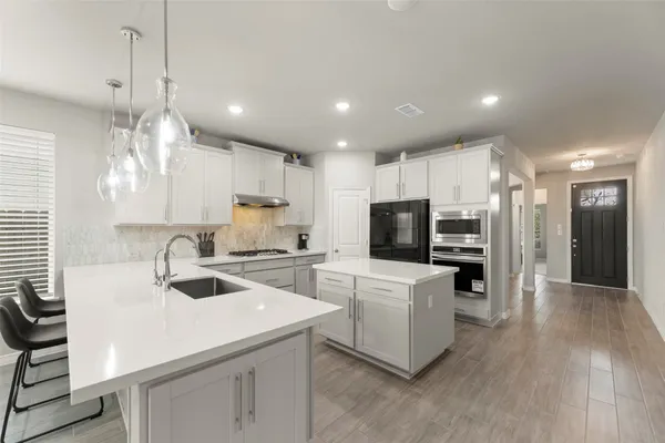 a kitchen with a sink a counter top space stainless steel appliances and cabinets