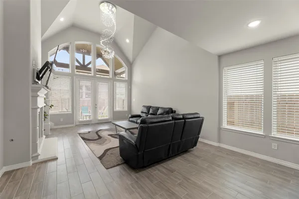 a living room with furniture and a large mirror next to a window