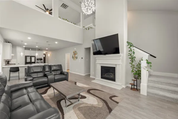 a living room with furniture a flat screen tv and a fireplace