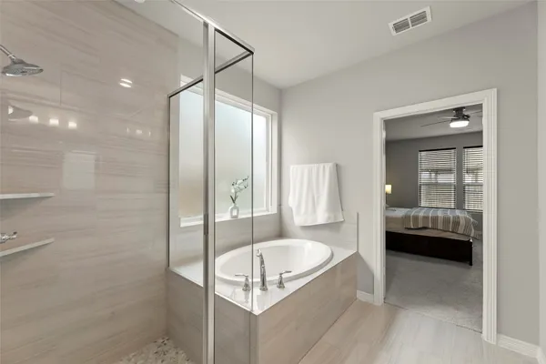 a bathroom with a tub shower and sink