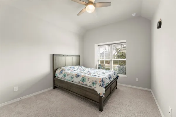 a bed sitting in a bedroom next to a window