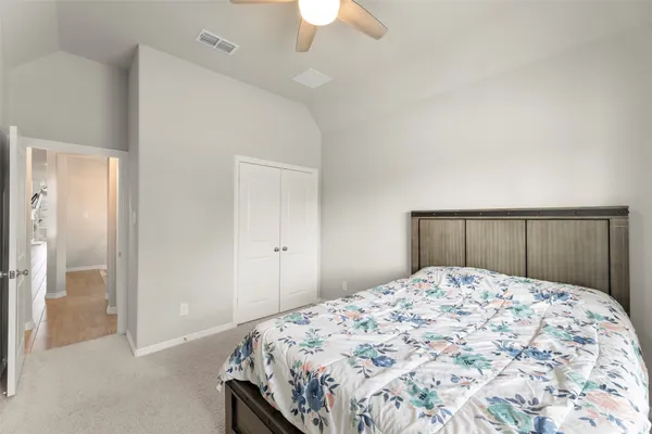a bedroom with a large bed and a chandelier