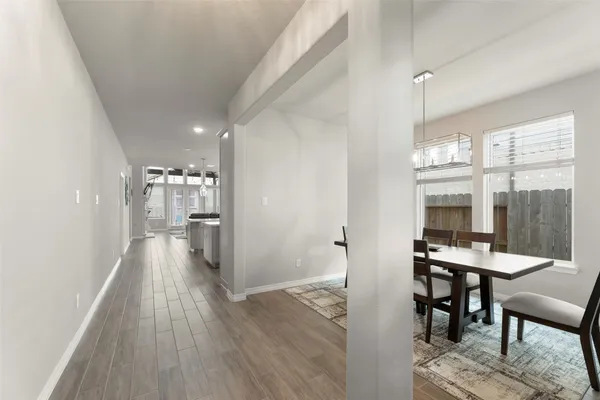 a view of a hallway with furniture and wooden floor