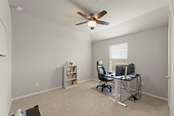 a view of a workspace with furniture and a window