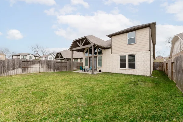a front view of a house with backyard and garden