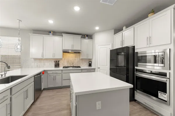 a kitchen with a refrigerator a sink and cabinets