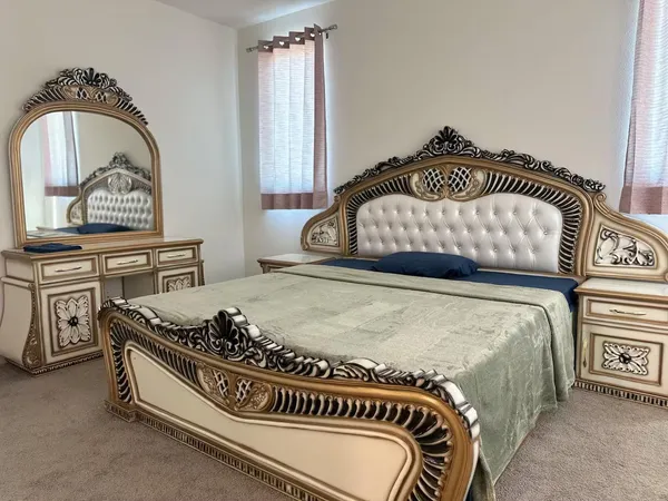 a bedroom with a bed and a painting on the wall