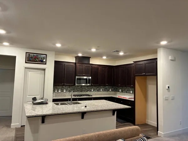 a kitchen with stainless steel appliances granite countertop a sink refrigerator and cabinets