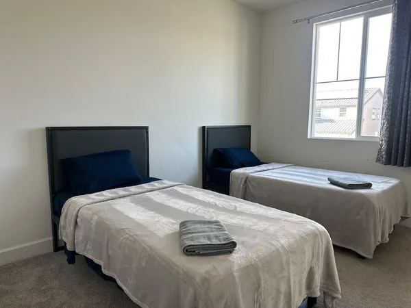 a bedroom with two bed and a window